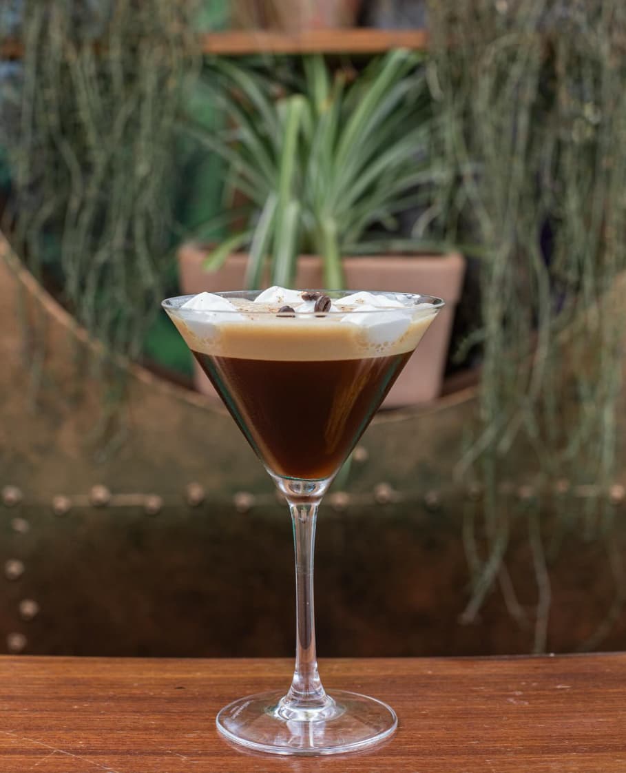 Presentación elegante de cóctel con decoración tropical en Astral Bar de Puerto Banús